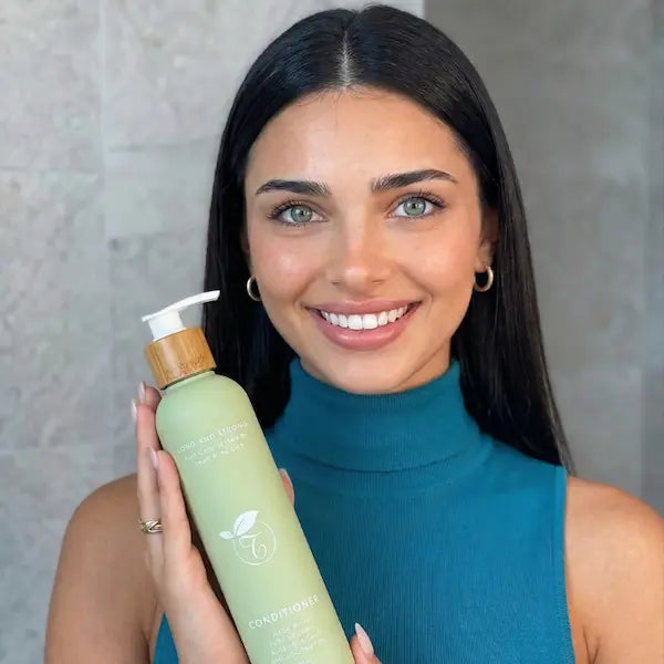 image of a woman happily presenting her haircare
