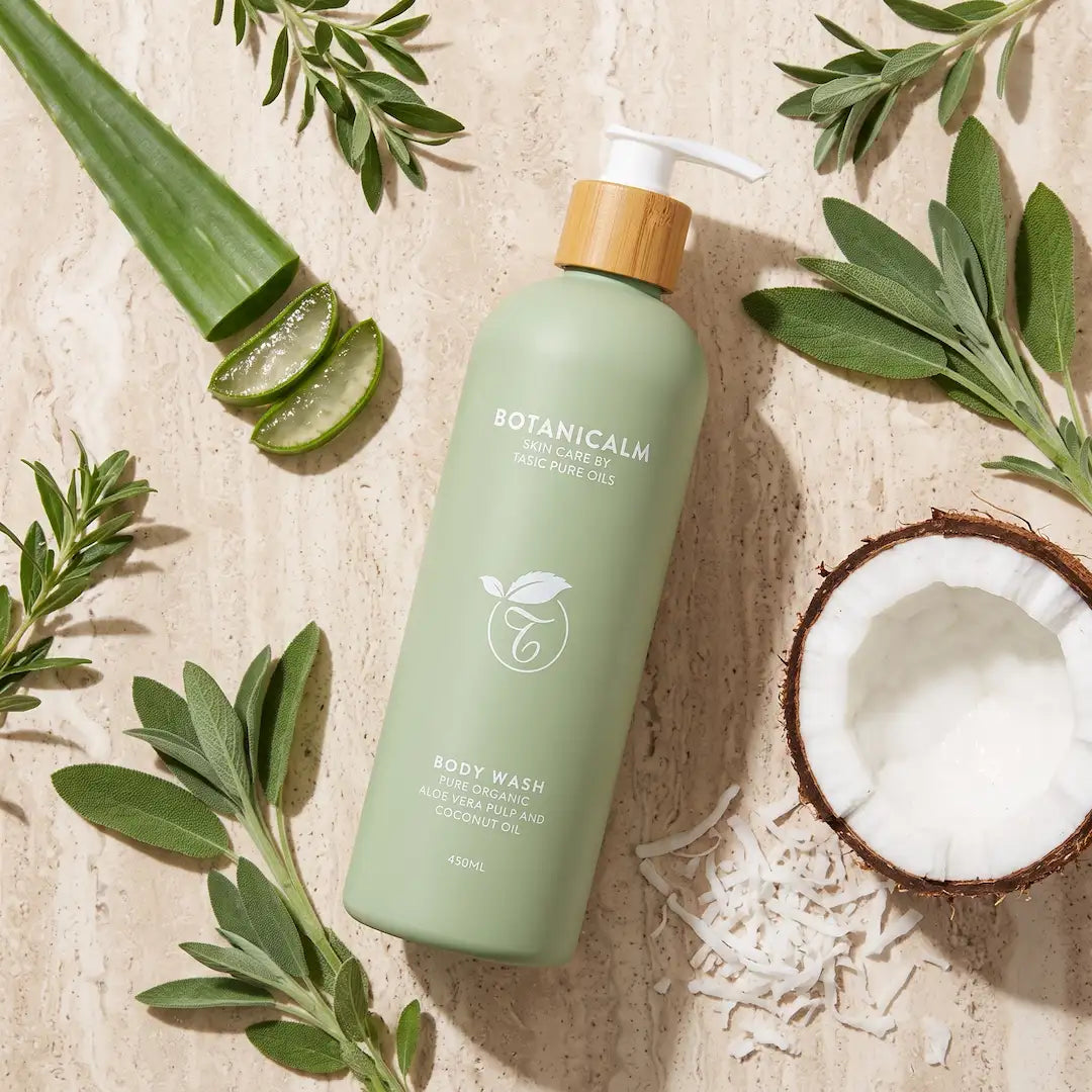 Luxury flatlay of Tasic Pure Oils BotaniCalm Aloe Vera and Coconut Body Wash bottle styled with aloe vera leaf, sage sprigs, and coconut