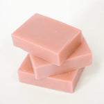 Three pink soap bars stacked on a white background